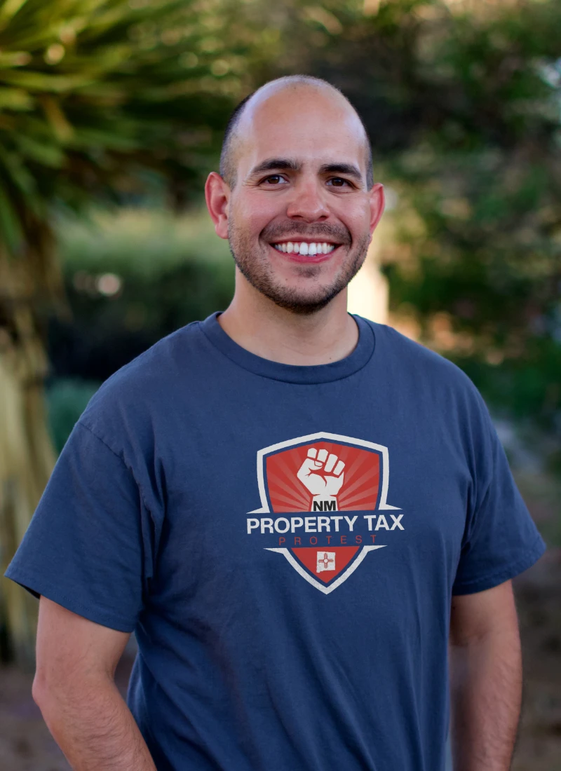 Isaac Ramos, Tax Protest Professional and co-founder of NM Property Tax Protest, smiling in branded shirt